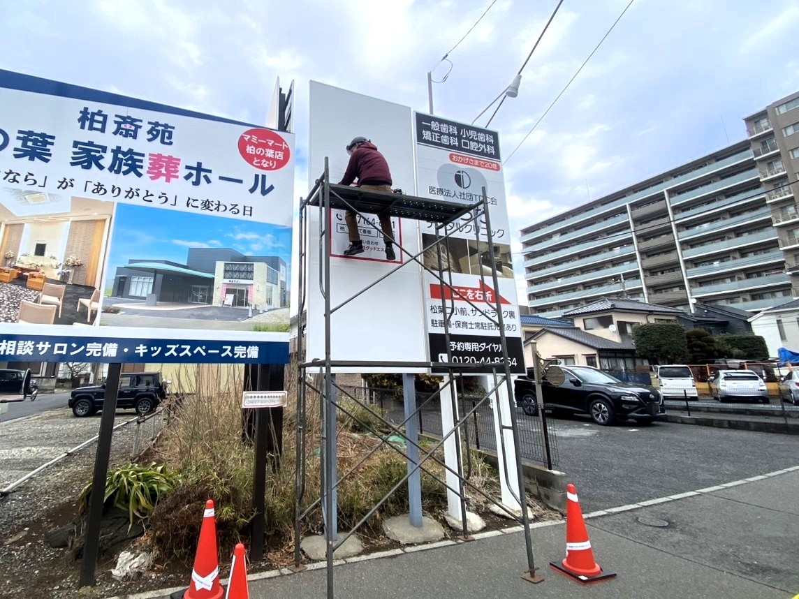 千葉県柏市の外壁塗装専門店「戸祭塗装 柏店」の案内看板。モラージュ柏近く、事務キチ柏店の交差点に設置。